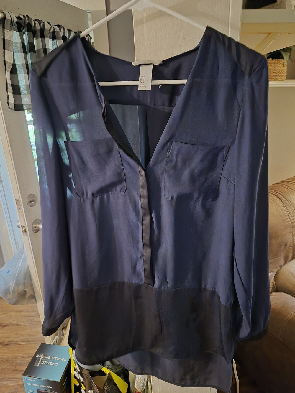 H&M navy blue satin blouse features two front pockets and a sheer V-neck design.